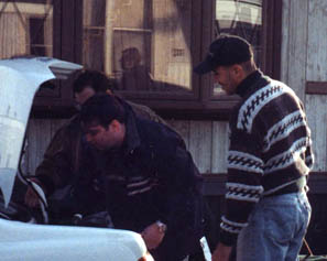 Rob and Alan of Oh the Humanity! loading their trunk, and Adrew of Badmovies.org giving advice.  Also Sue reflected in the window.